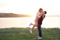 Happy loving couple dancing near river at sunset Royalty Free Stock Photo