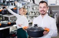 Happy loving couple deciding on best saucepan