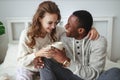 Happy loving couple drinking cocoa on winter morning in bed Royalty Free Stock Photo