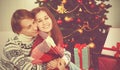 Happy loving couple in embrace warmed at Christmas tree Royalty Free Stock Photo