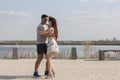 Happy loving couple embracing and kissing outdoors at summertime under blue sky. Love story. Couple in love. Sea background. Royalty Free Stock Photo