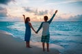 Happy loving couple enjoy sunset beach, family hands up at sky Royalty Free Stock Photo