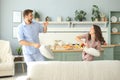Happy loving couple having fun while having a pillow fight in the living room Royalty Free Stock Photo