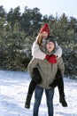 Happy loving couple is having fun in winter outdoors. Guy rolls girl on his back Royalty Free Stock Photo