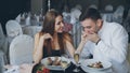 Happy loving couple is holding hands, talking and kissing during romantic dinner in restaurant. Affectionate Royalty Free Stock Photo