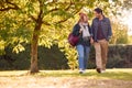 Happy Loving Couple Holding Hands Walking In Autumn Park Together Royalty Free Stock Photo