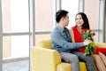 Happy loving couple. husband gives his wife flowers at home