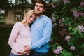 Happy loving couple with pregnant woman walking in spring park Royalty Free Stock Photo