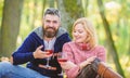 Happy loving couple relaxing in park together. Romantic picnic with wine in forest. Couple in love celebrate anniversary Royalty Free Stock Photo