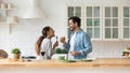 Happy loving couple singing, having fun with kitchenware in kitchen Royalty Free Stock Photo