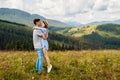 Happy loving couple of tourists walking in Carpathian mountains enjoying view. Man lifts woman. Travelers have fun Royalty Free Stock Photo