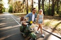 Happy loving couple walking with scooter outdoors Royalty Free Stock Photo