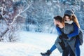 Happy loving couple walking in snowy winter forest, spending christmas vacation together. Outdoor seasonal activities Royalty Free Stock Photo