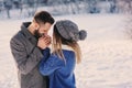 Happy loving couple walking in snowy winter forest, spending christmas vacation together. Outdoor seasonal activities. Royalty Free Stock Photo