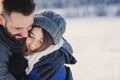 Happy loving couple walking in snowy winter forest, spending christmas vacation together. Outdoor seasonal activities. Royalty Free Stock Photo