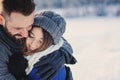 Happy loving couple walking in snowy winter forest, spending christmas vacation together. Outdoor seasonal activities.