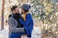 Happy loving couple walking in snowy winter forest, spending christmas vacation together. Outdoor seasonal activities. Royalty Free Stock Photo