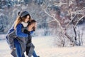 Happy loving couple walking in snowy winter forest, spending christmas vacation together. Outdoor seasonal activities. Royalty Free Stock Photo