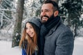 Happy loving couple walking in snowy winter forest, spending christmas vacation together. Outdoor seasonal activities Royalty Free Stock Photo