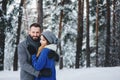 Happy loving couple walking in snowy winter forest, spending christmas vacation together. Outdoor seasonal activities Royalty Free Stock Photo
