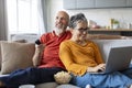 Happy loving elderly couple spending time together on couch at home Royalty Free Stock Photo