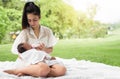 Happy loving family. Asian young beautiful mother and holding her newborn child touching gently and feeding baby bottle with love Royalty Free Stock Photo