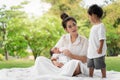 Happy loving family. Asian young beautiful mother and holding her newborn child touching gently and feeding baby bottle with love Royalty Free Stock Photo