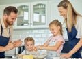 Happy loving family are baking together. Mother, father and two daughters are making cookies and having fun in the Royalty Free Stock Photo