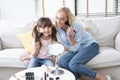 Happy loving family. Beautiful mom with her little cute daughter are doing your makeup and having fun. Mom and daughter holding Royalty Free Stock Photo