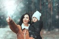Happy loving family! Beautiful mother and child girl having fun, playing and laughing on snowy winter walk in nature. Frost winter Royalty Free Stock Photo
