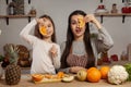 Mother and her daughter are doing a fruit cutting and having fun at the kitchen. Royalty Free Stock Photo