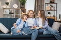 Happy loving family at home. Pretty young caucasian mother reading a book to her daughters Royalty Free Stock Photo