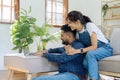 Happy loving family Indian couple hugging on couch at home and focused on laptop screen Royalty Free Stock Photo