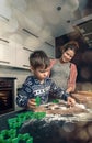 Happy loving family in the kitchen before Christmas. Mother and child preparing the dough, bake ginger cookies Royalty Free Stock Photo