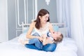 A happy, loving family. Mom and baby son play at home on the bed, have fun and laugh Royalty Free Stock Photo