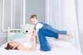 A happy, loving family. Mom and baby son play at home on the bed, have fun and laugh Royalty Free Stock Photo