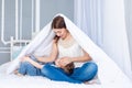 A happy, loving family. Mom and baby son play at home on the bed under the blanket Royalty Free Stock Photo