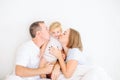 Happy and loving family morning concept. Cheerful parents in sleepwear having fun with their daughter on the bed. Family spending Royalty Free Stock Photo