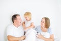 Happy and loving family morning concept. Cheerful parents in sleepwear having fun with their daughter on the bed. Family spending Royalty Free Stock Photo