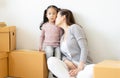 Happy loving family. Mother and child girl unpacking cardboard boxes, playing, kissing and hugging for their new home. Moving Royalty Free Stock Photo