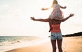 Happy loving family mother and daughter having fun on the beach at sunset - Mum piggyback with her kid next sea during summer Royalty Free Stock Photo