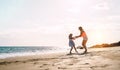 Happy loving family mother and daughter having fun on the beach at sunset - Mum playing with her kid next sea in holidays Royalty Free Stock Photo