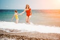 Happy loving family mother and daughter having fun together on the beach. Mum playing with her kid in holiday vacation Royalty Free Stock Photo