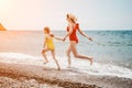 Happy loving family mother and daughter having fun together on the beach. Mum playing with her kid in holiday vacation Royalty Free Stock Photo