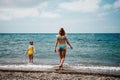 Happy loving family mother and daughter having fun together on the beach. Mum playing with her kid in holiday vacation Royalty Free Stock Photo