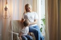 Happy loving family with mother and daughter in living room. Woman mom and small child girl playing and having Royalty Free Stock Photo