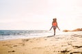 Happy loving family mother and daughter running and having fun on the beach at sunset - Mom piggyback her kid next to ocean Royalty Free Stock Photo