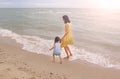 Happy loving family. Mother and her daughter child girl playing on beach background in the evening Royalty Free Stock Photo