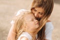 Happy loving family. Mother and her daughter child girl playing and hugging. alley of big trees. close up view Royalty Free Stock Photo