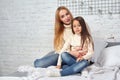 Mother and her daughter child girl playing and hugging on bed Royalty Free Stock Photo